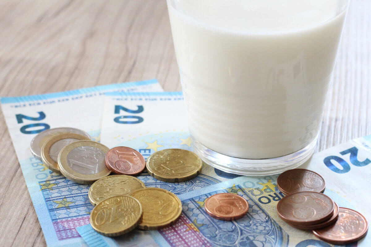 Münzen neben einem Glas Milch